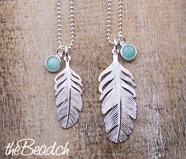 two silver necklace feather
